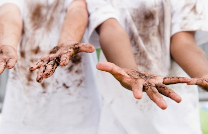 Two kids with mud dirty white shirts 