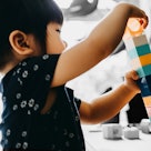 A child learning how to put building blocks together before kindergarten