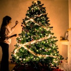 A girl decorating a Christmas tree in a living room