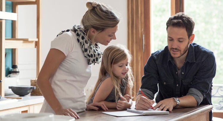 A mom, dad and their daughter calculating the cost of education on a notepad