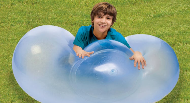 A young boy lying on a Wubble Bubble