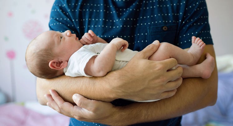 A father holding his 8 weeks old daughter in his arms