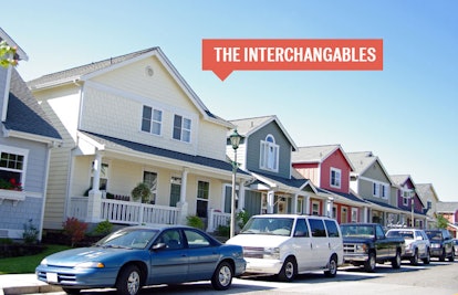 A row of houses in the suburbs with cars parked in front and a sign saying The Interchangables