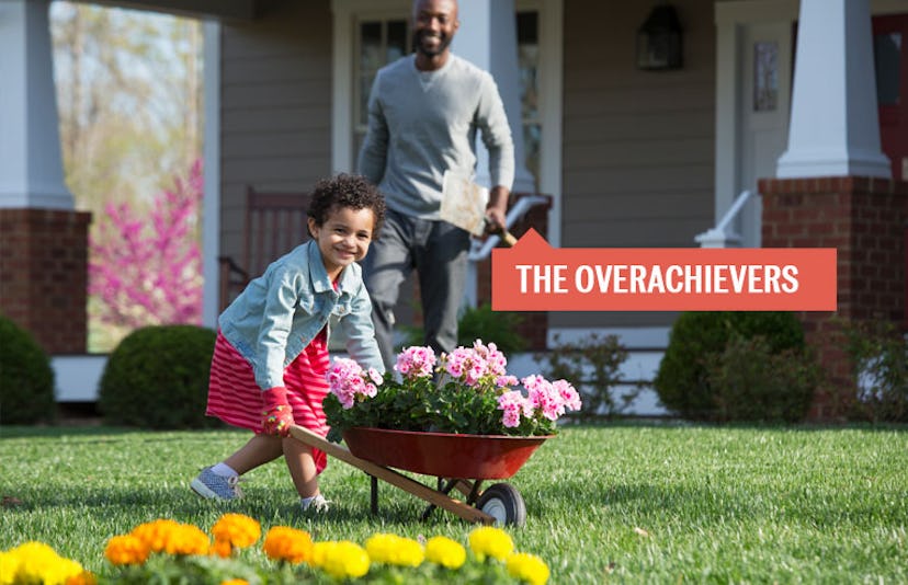 A father walking towards his daughter who is pushing a wheelbarrow full of flowers with a sign sayin...