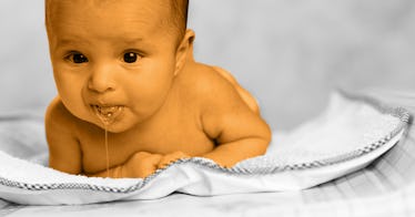 baby spitting up on a white blanket