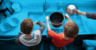 family rules is depicted by two boys. cleaning up their dishes in a sink
