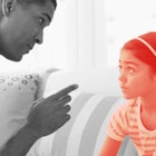sepia edit of a father trying to discipline a strong-willed child by speaking to her calmly about th...