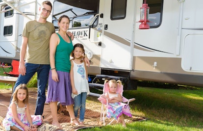A family of five standing next to their RV