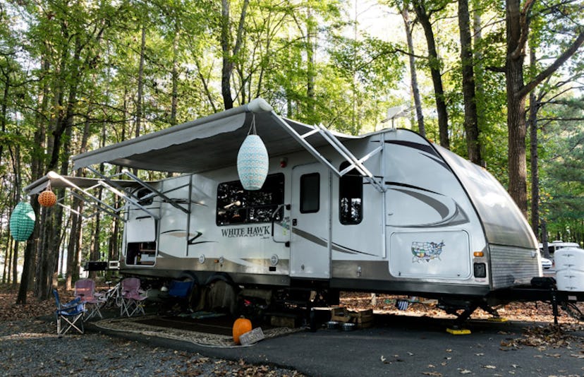 An RV in the forest, parked and open 