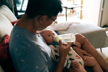 A dad bottle feeding his infant.