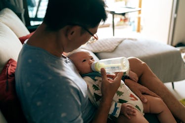 A dad bottle feeding his infant.