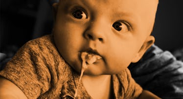 A baby spitting up while looking over his shoulder