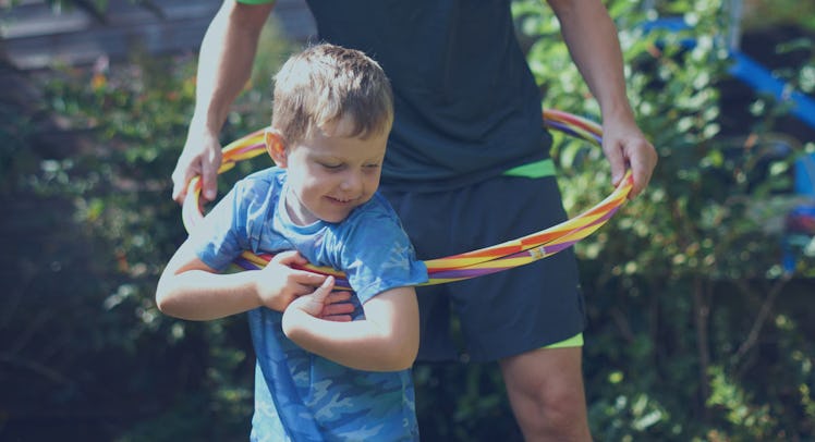 A father and son playing with a hula hoop
