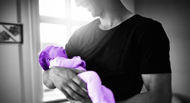 greyscale edit of dad in black shirt rocking yawning newborn baby to sleep
