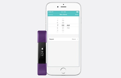 Fitbit fitness tracker and Fitbit application on a screen of a mobile phone