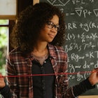 Storm Reid from a wrinkle of time standing in front of a black board explaining the tesseract