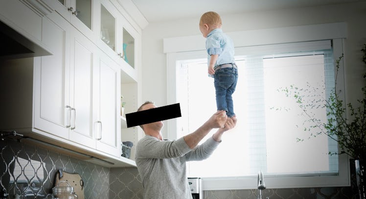 A dad balancing his baby on his extended hands.