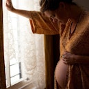 Pregnant woman breathing and leaning on a wall.
