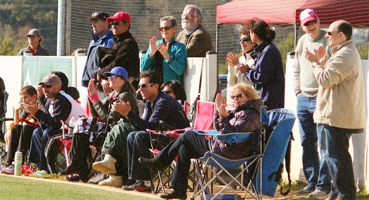 Dads watching a kids match on the sidelines of a field