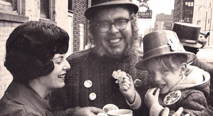 An old photo of a dad holding his son and his wife smiling next to them