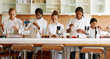 Young students wearing lab coats