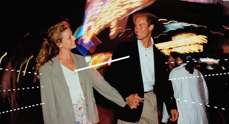 woman and man holding hands as they walk down the street