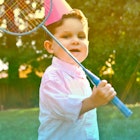 3-Year-Old playing badminton outdoors at a birthday party.