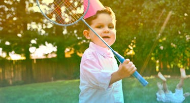 3-Year-Old playing badminton outdoors at a birthday party.