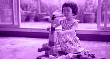 Kid playing alone with building blocks.