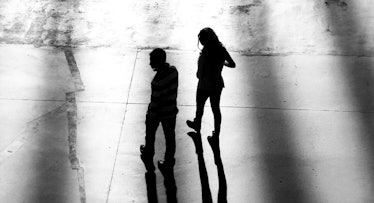 grey scale edit of man and woman walking in an alley