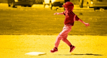 A child in a baseball outfit running bases on the baseball court