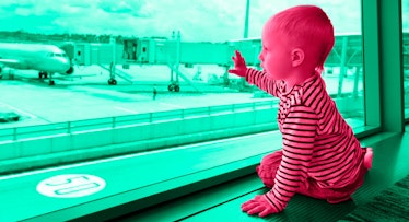 A toddler sitting next to a window at the airport, looking out at the landing planes