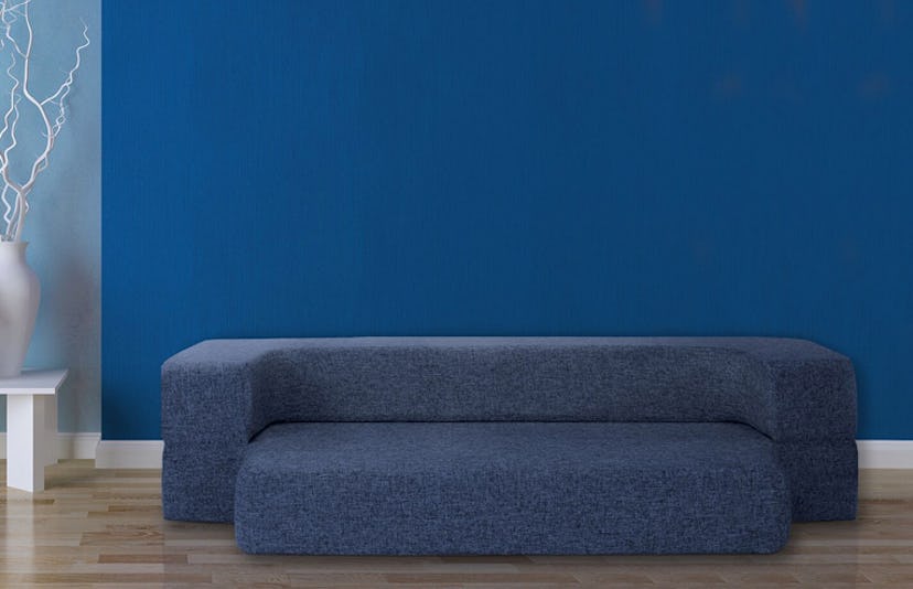 CouchBed featured in a living room in front of a blue wall