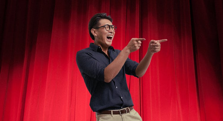 A dad on a comedy club stage, telling dad jokes