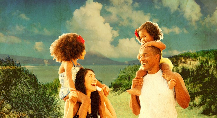 A mother and a father both holding each of their twin toddlers on their family vacation
