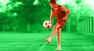 A young boy juggling a soccer ball