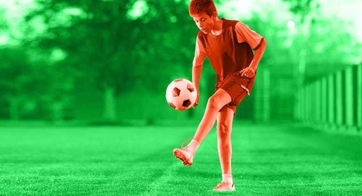 A young boy juggling a soccer ball