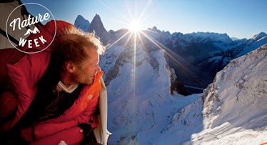 Conrad Anker looking out of his tent in the middle of a mountain site