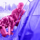 A father teaching a Kid to Pitch a Tent