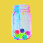 A rewards jar with candy in it for kids with a yellow background