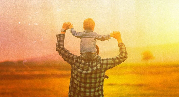 A dad holding his son on his shoulders while walking