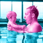 A father holding his little baby while standing in a pool
