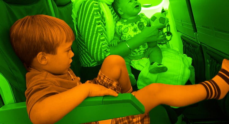 A woman holding her baby, while her toddler son is sitting next to them, during an airplane flight.