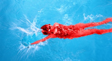 A boy in a swimming pool swimming the backstroke with goggles