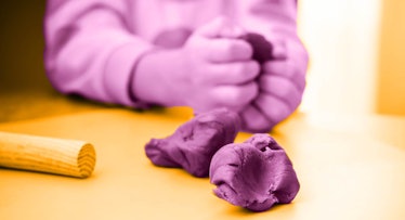  Child's hands playing with homemade playdough.