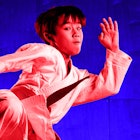 A boy in movement who is practicing martial arts for self-defense with a red and blue color filter