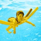 A kid playing with a Pool Noodle