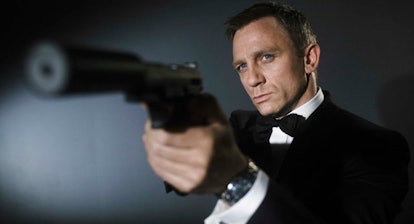 Daniel Craig as James Bond with a silenced gun pointing off camera