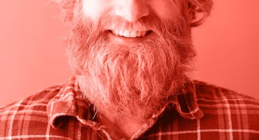 redscale edit of a headshot of a man with a beard smiling and wearing a flannel shirt