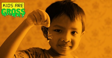 A small boy holding an insect with his hand